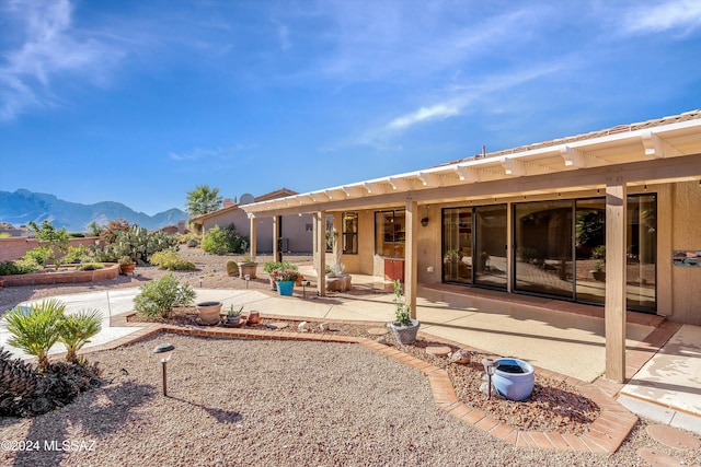 back of house with a mountain view and a patio area