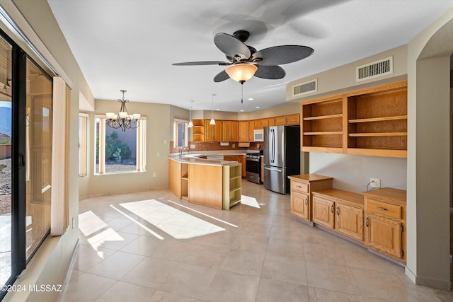 kitchen featuring pendant lighting, light tile patterned floors, stainless steel appliances, and ceiling fan with notable chandelier