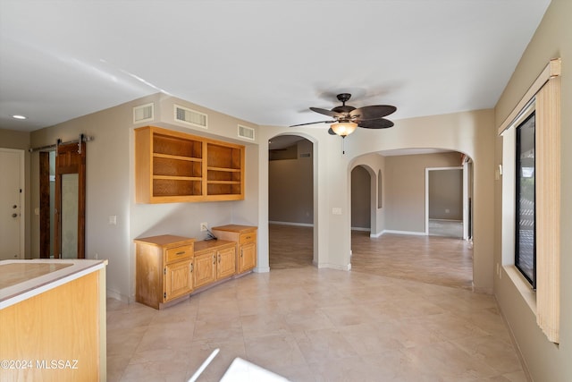 kitchen featuring a barn door and ceiling fan