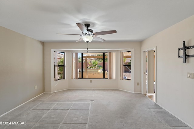 carpeted empty room featuring ceiling fan