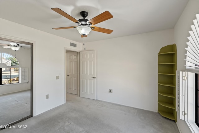 unfurnished bedroom with ceiling fan and light colored carpet