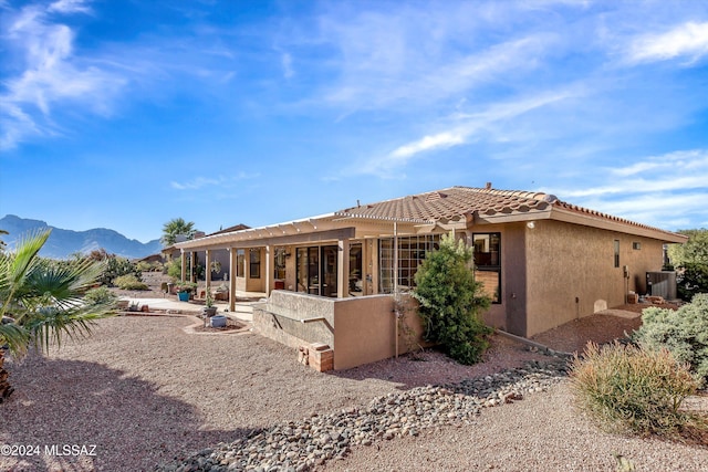 rear view of property featuring central air condition unit, a patio area, and a mountain view