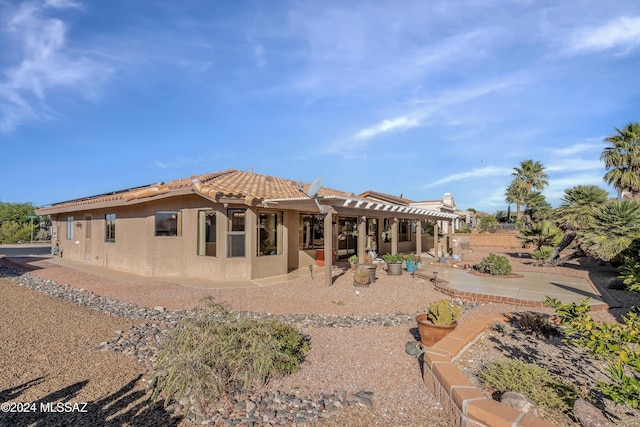 rear view of property with a patio area and a pergola