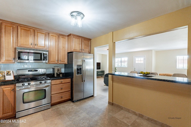 kitchen with appliances with stainless steel finishes and decorative backsplash