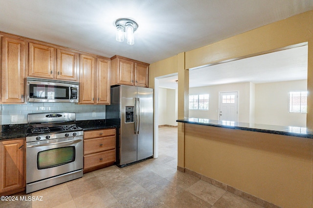 kitchen featuring dark stone countertops, stainless steel appliances, and decorative backsplash