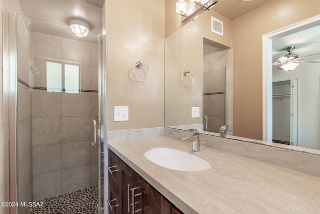 bathroom featuring vanity, ceiling fan, and walk in shower