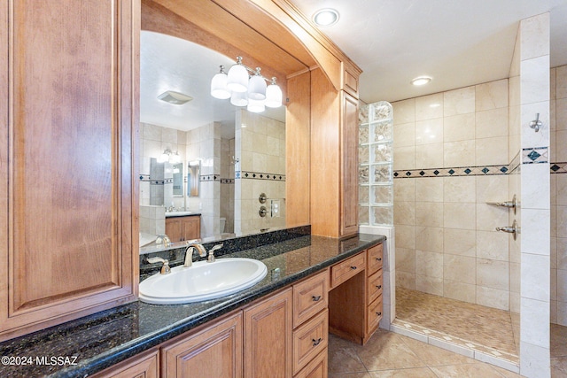 bathroom with vanity, tile patterned flooring, and tiled shower