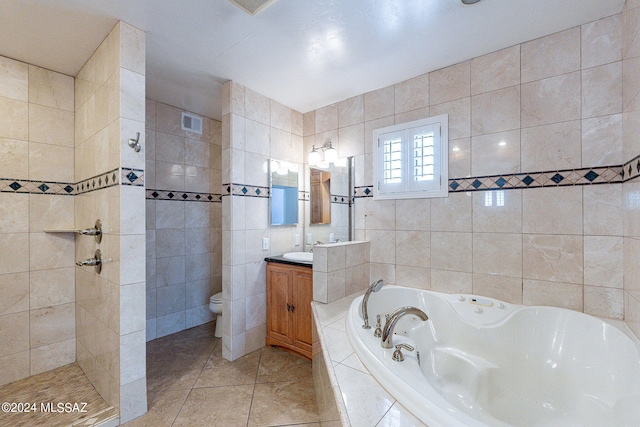 full bathroom featuring shower with separate bathtub, toilet, tile walls, vanity, and tile patterned flooring