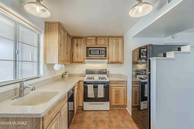 kitchen featuring light tile patterned floors, gas range oven, a sink, black dishwasher, and stainless steel microwave