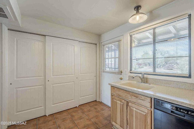 kitchen with light tile patterned floors, visible vents, dishwasher, light countertops, and a sink