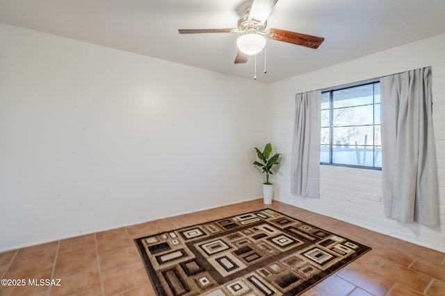 tiled empty room featuring a ceiling fan