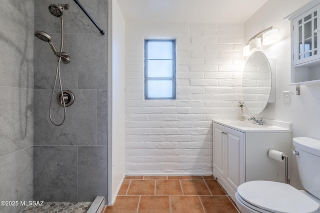 full bathroom with tiled shower, vanity, and toilet