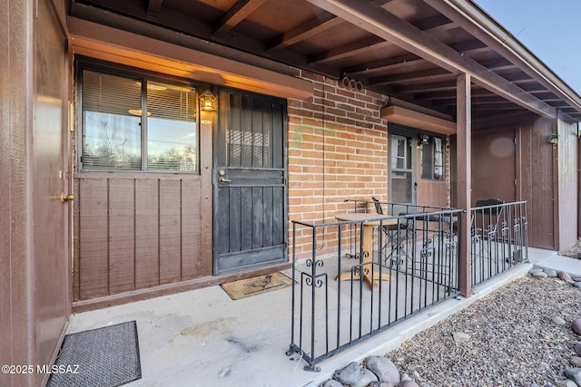 view of exterior entry with brick siding