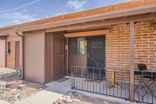 view of exterior entry featuring brick siding