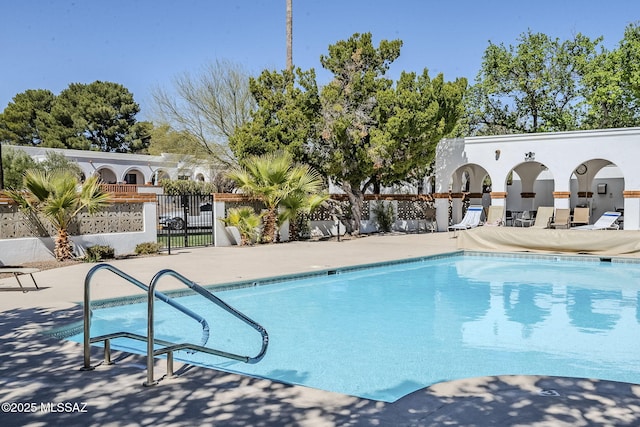 community pool featuring fence and a patio