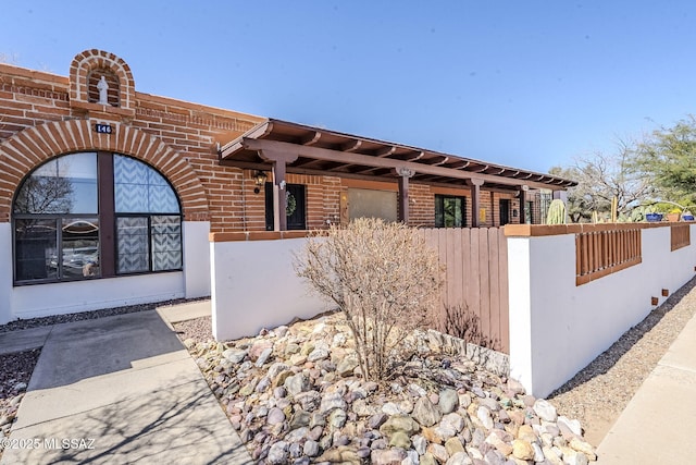 exterior space with brick siding and fence