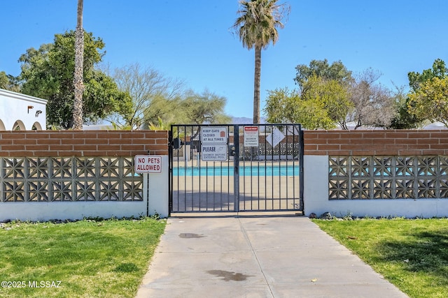 view of gate with a yard and fence