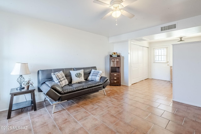 living room featuring a ceiling fan, visible vents, and baseboards