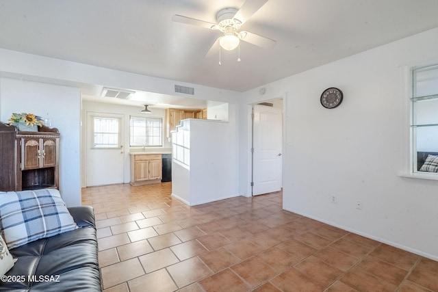 unfurnished living room featuring baseboards, a sink, visible vents, and a ceiling fan