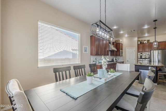 tiled dining space featuring an inviting chandelier