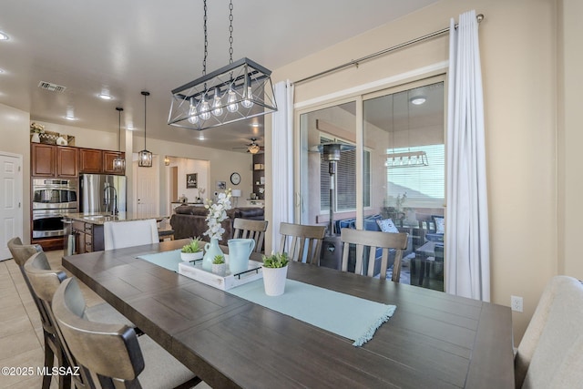 tiled dining space with ceiling fan and sink