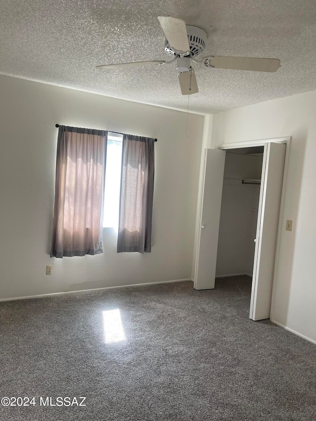 unfurnished bedroom featuring a closet, ceiling fan, a textured ceiling, and carpet floors