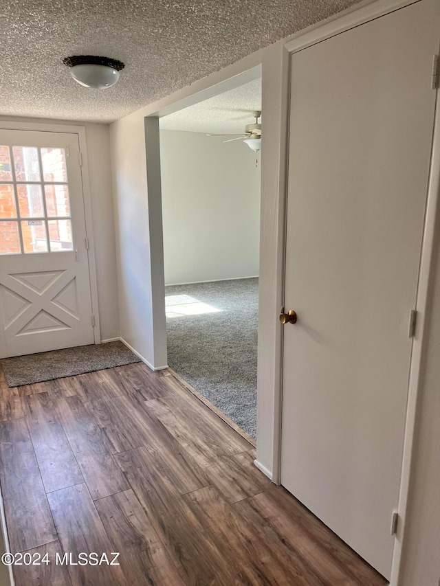 interior space with a textured ceiling, hardwood / wood-style flooring, and ceiling fan