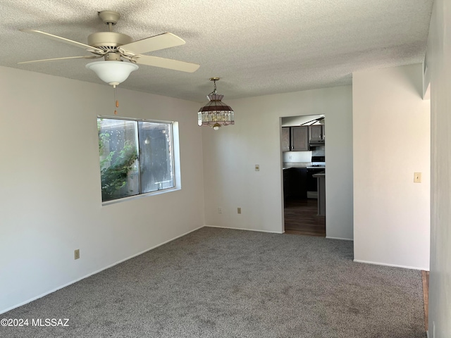 carpeted spare room featuring a textured ceiling and ceiling fan