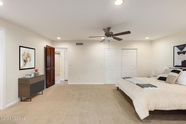 bedroom with light carpet, a closet, and ceiling fan