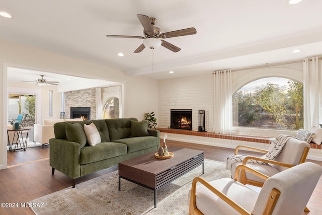 living room with ceiling fan, hardwood / wood-style floors, and a fireplace