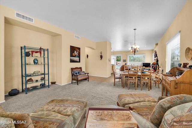 living room featuring light colored carpet, an inviting chandelier, and a wealth of natural light