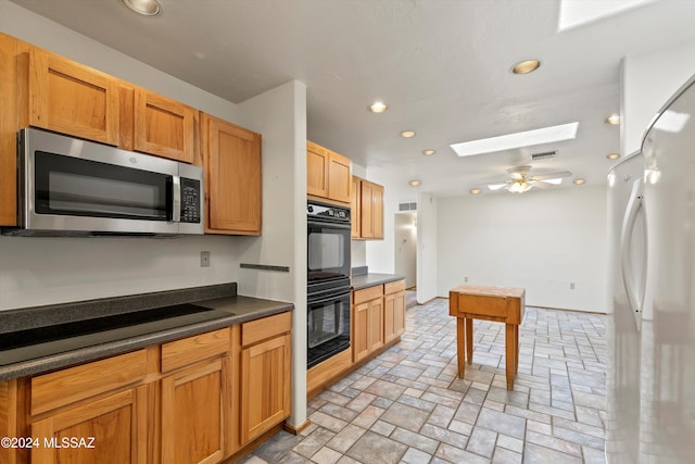 kitchen featuring a skylight, ceiling fan, and black appliances