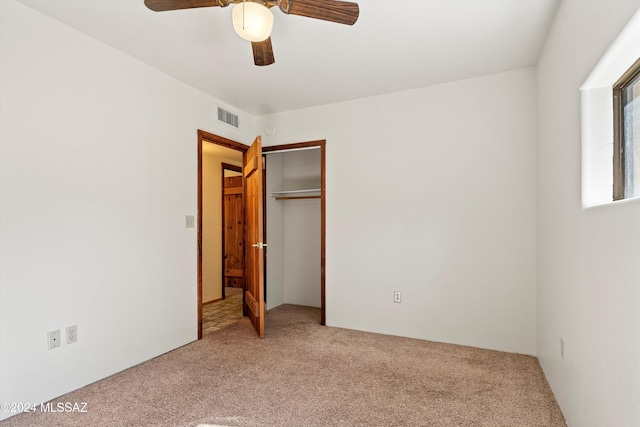 unfurnished bedroom with carpet, a closet, and ceiling fan