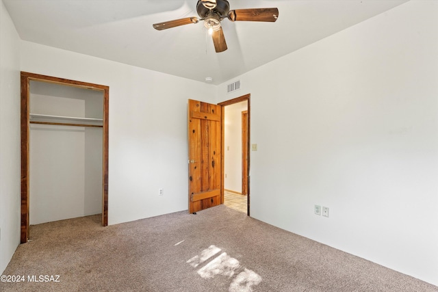 unfurnished bedroom with light carpet, a closet, and ceiling fan