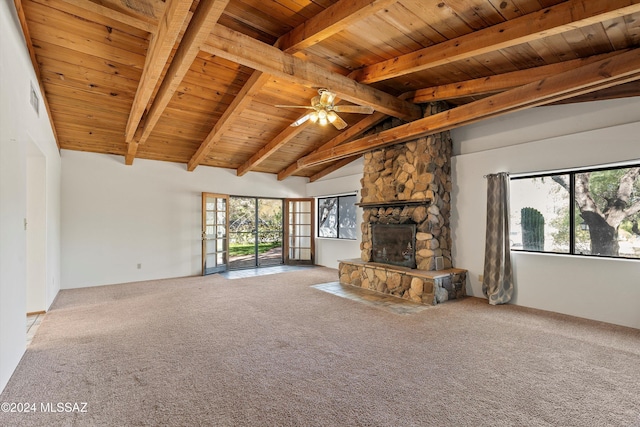 unfurnished living room featuring a fireplace, plenty of natural light, carpet, and lofted ceiling with beams