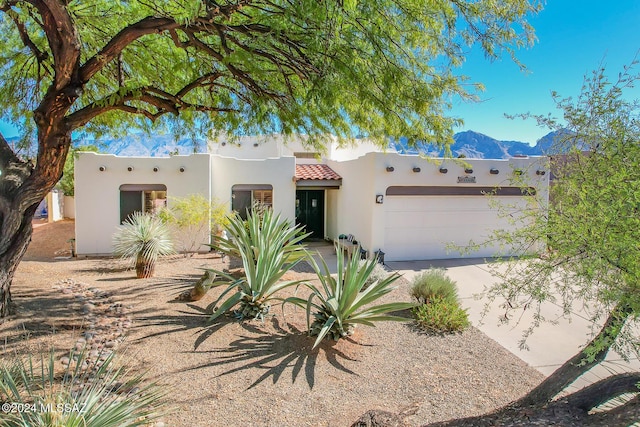 adobe home with a mountain view and a garage