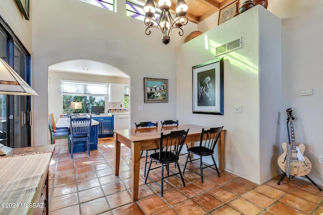 dining area featuring wood ceiling, a towering ceiling, a chandelier, and beamed ceiling