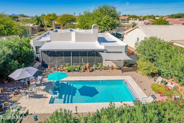 view of pool featuring a sunroom, a patio, and a water slide