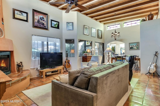 living room featuring light tile patterned flooring, wooden ceiling, a large fireplace, beam ceiling, and ceiling fan with notable chandelier