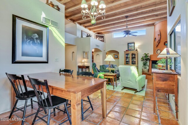 dining area featuring a notable chandelier, wooden ceiling, beamed ceiling, and a high ceiling