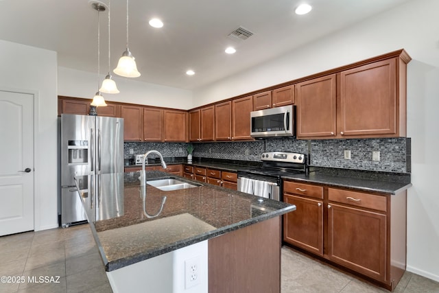 kitchen with visible vents, backsplash, appliances with stainless steel finishes, a sink, and dark stone counters