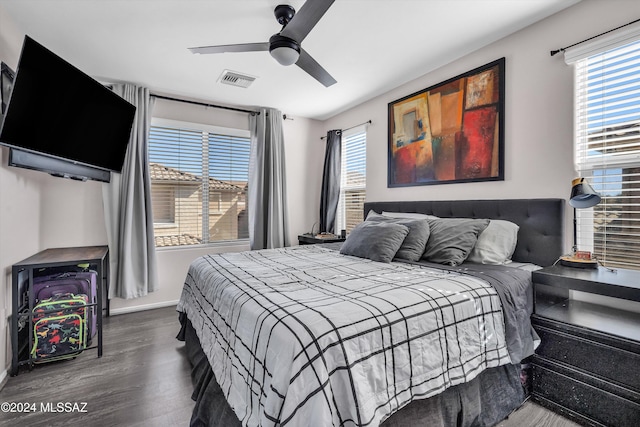 bedroom with ceiling fan, wood-type flooring, and multiple windows