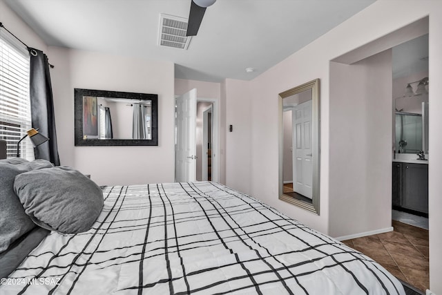 bedroom with ceiling fan, connected bathroom, and tile patterned floors