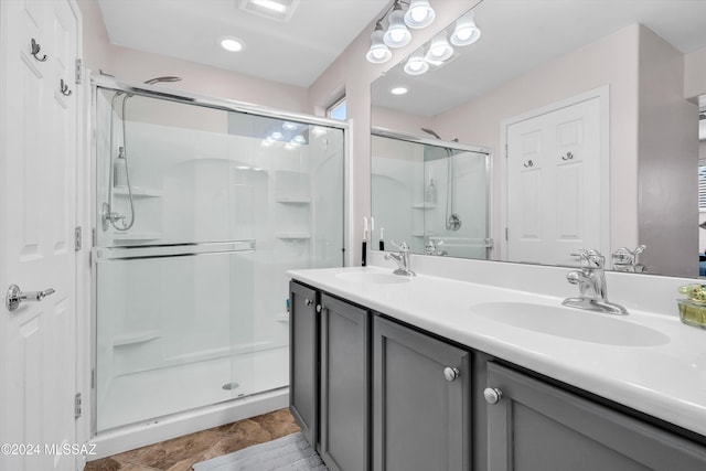 bathroom with vanity and a shower with door