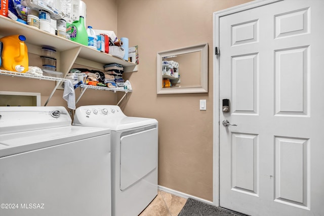 laundry area with light tile patterned floors and washer and dryer