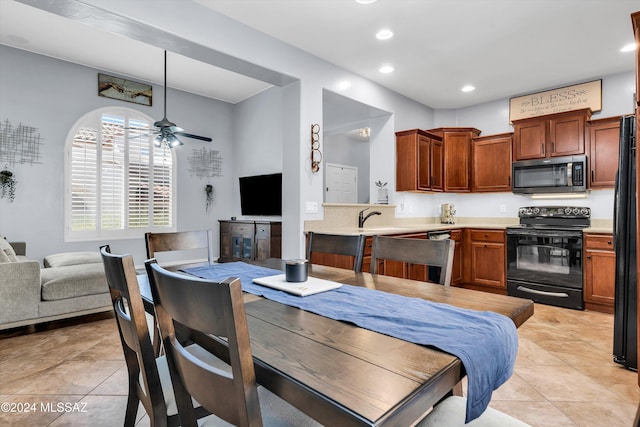 kitchen featuring light tile patterned flooring, sink, black appliances, kitchen peninsula, and ceiling fan