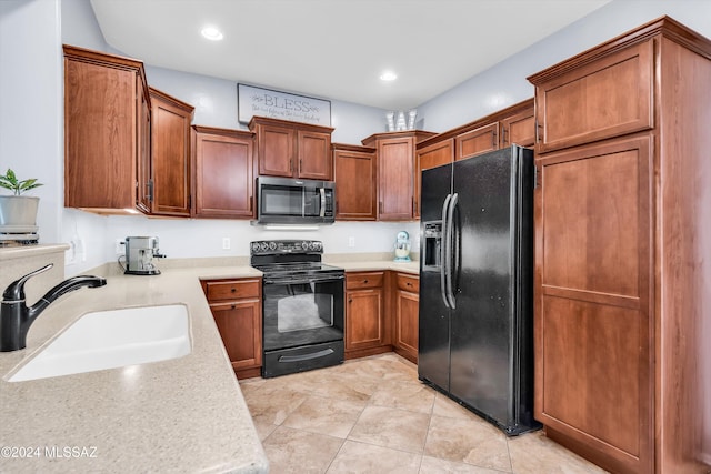 kitchen with light tile patterned floors, sink, and black appliances