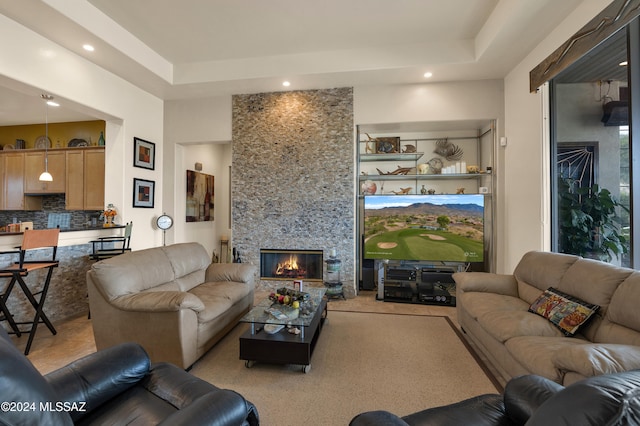 living room featuring a tray ceiling and a fireplace