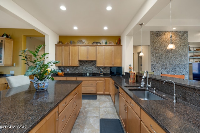 kitchen with light tile patterned flooring, hanging light fixtures, sink, dishwasher, and dark stone countertops