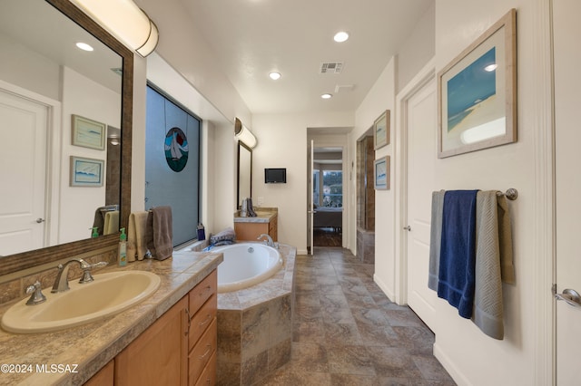 bathroom featuring vanity and tiled tub